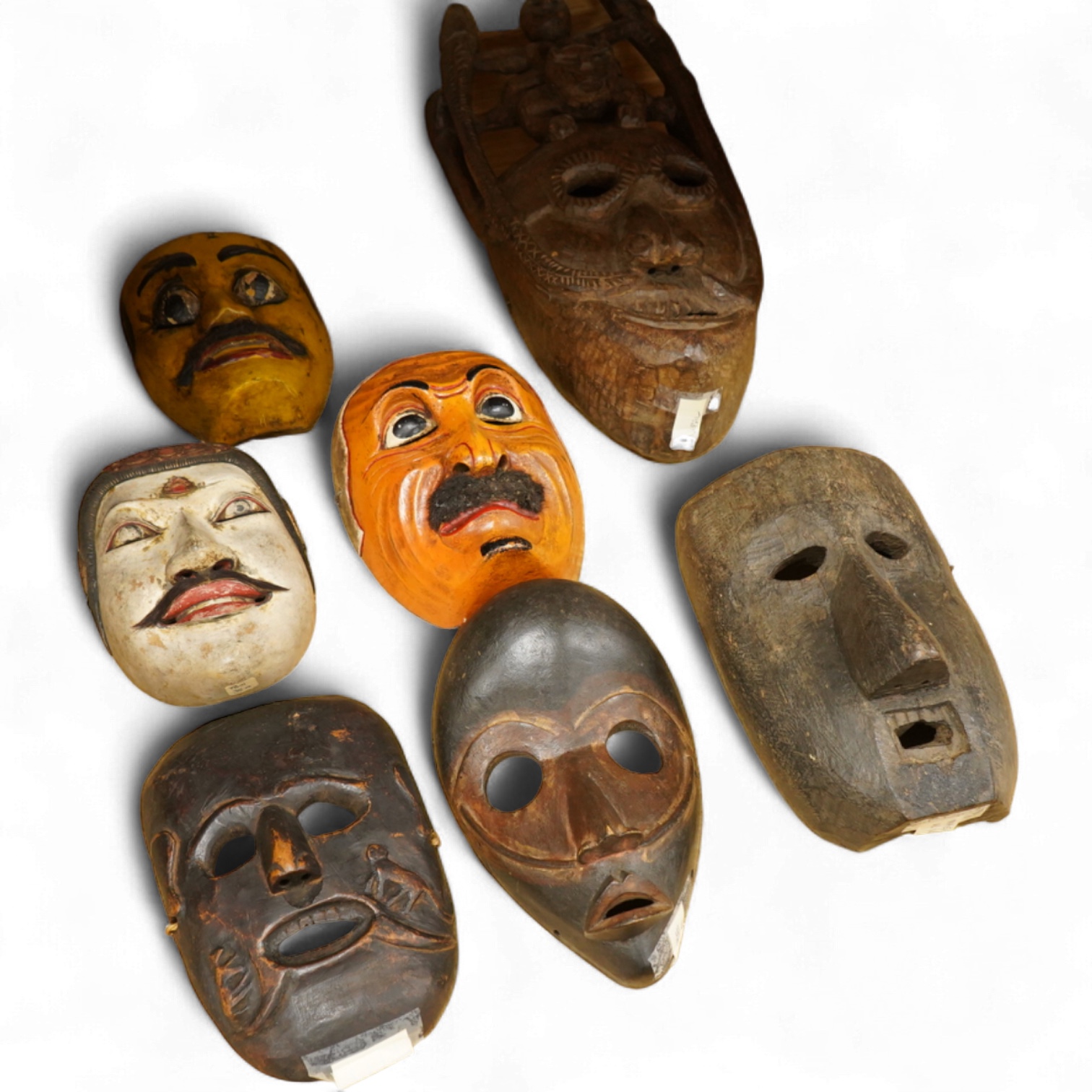 A collection of seven Nepalese, African and Indonesian masks to include a Magar example and one from the Dan Tribe, Liberia, largest 40cm
